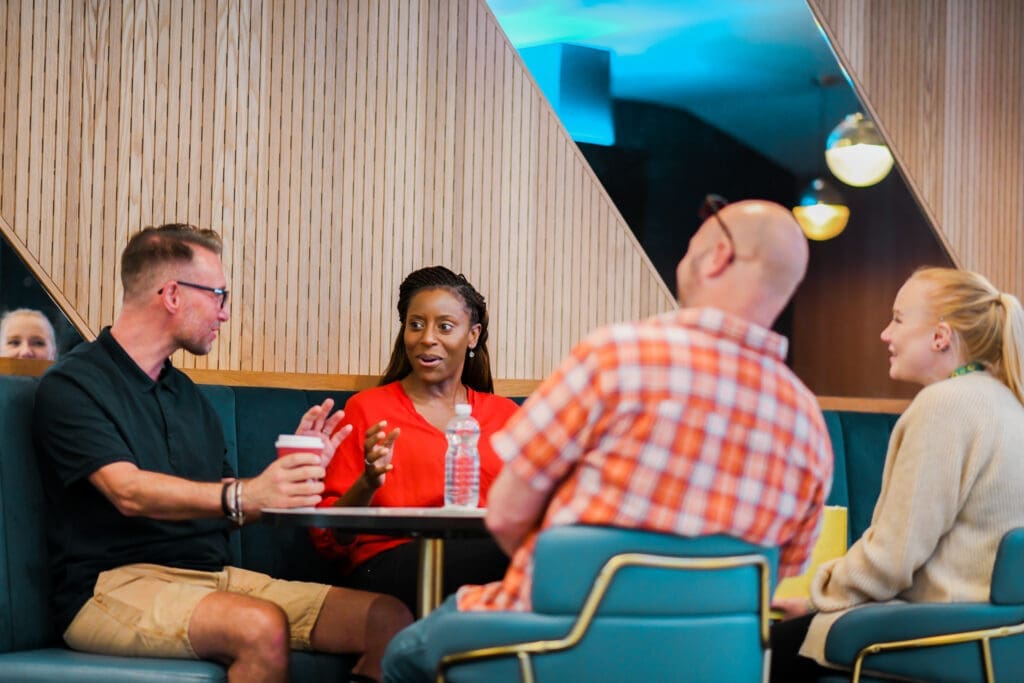 Group of customer laugh at a seating area in cinema, some have disabilities