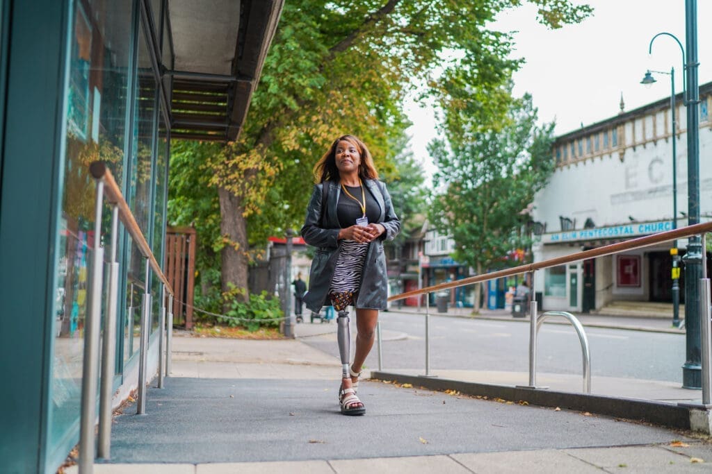 Person with limb loss / a prosthetic limb walking up a ramp