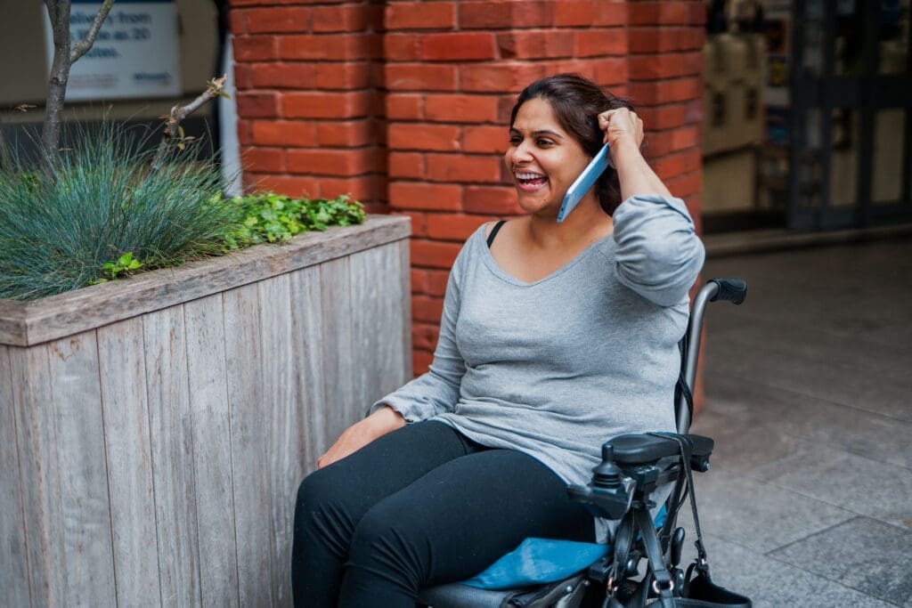 Wheelchair user makes a phone call outside