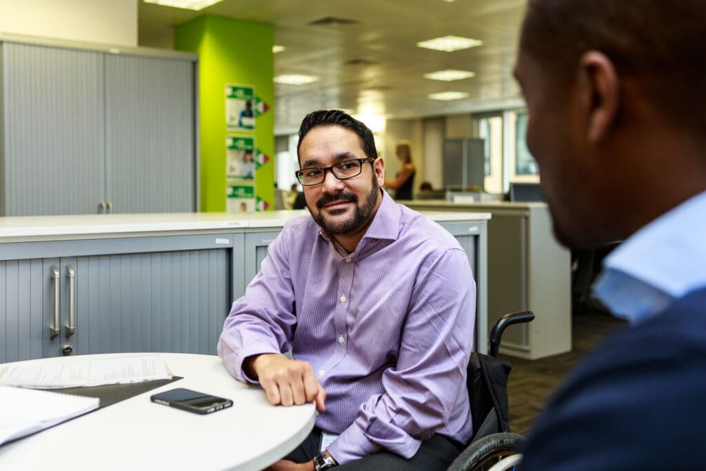 A man in a wheelchair in a business meeting.