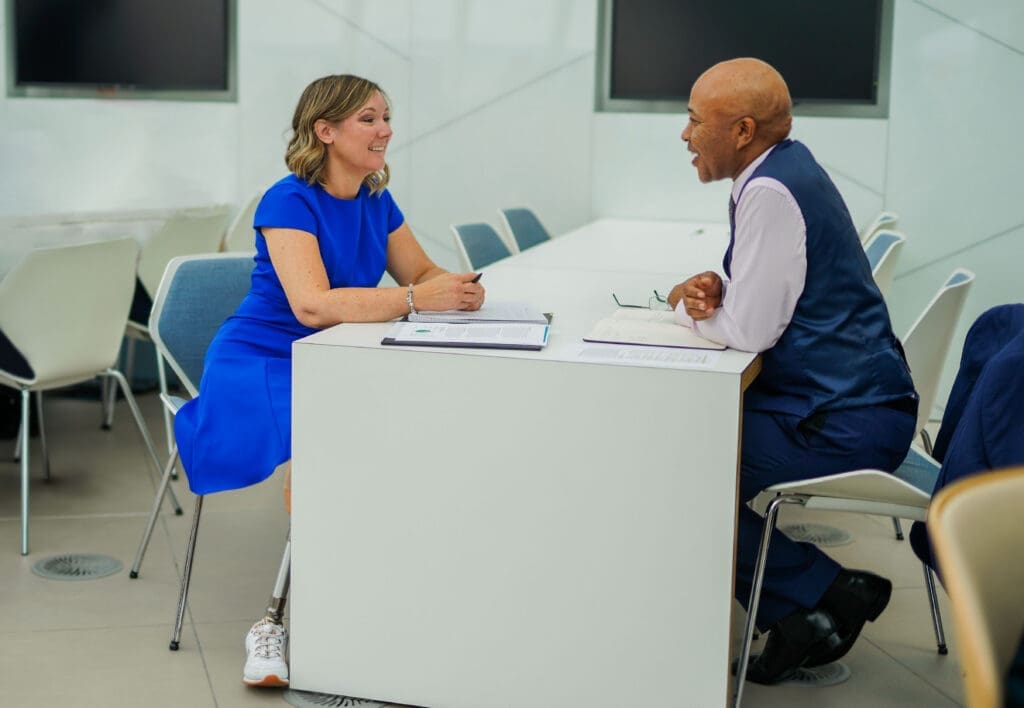 Woman with limb loss interacts with colleague at workplace meeting