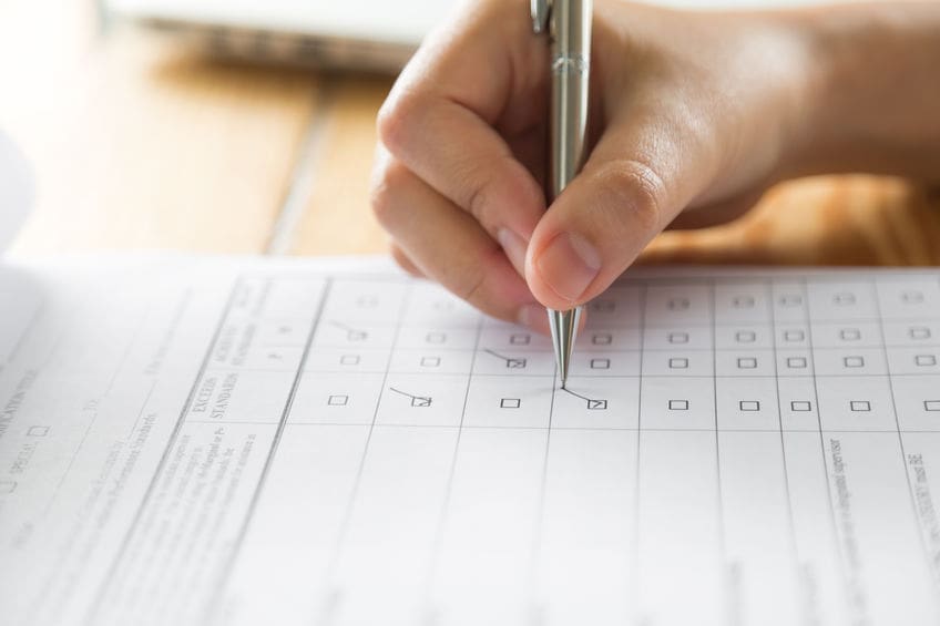 Hand with pen over application form.