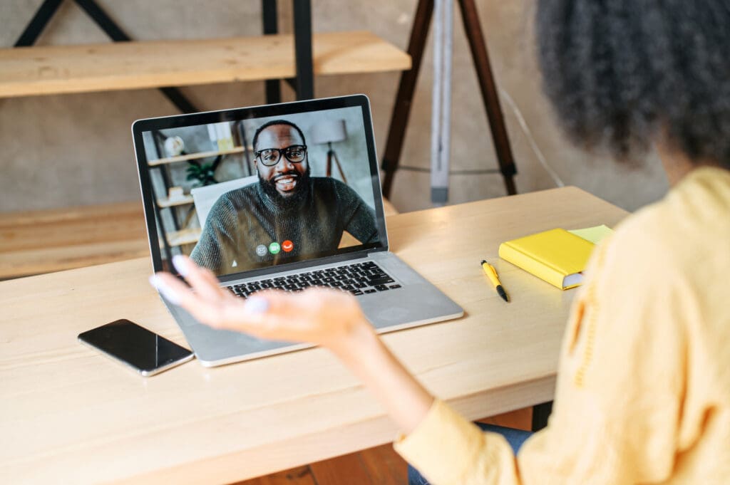 A woman speaks to a candidate by video call on her laptop