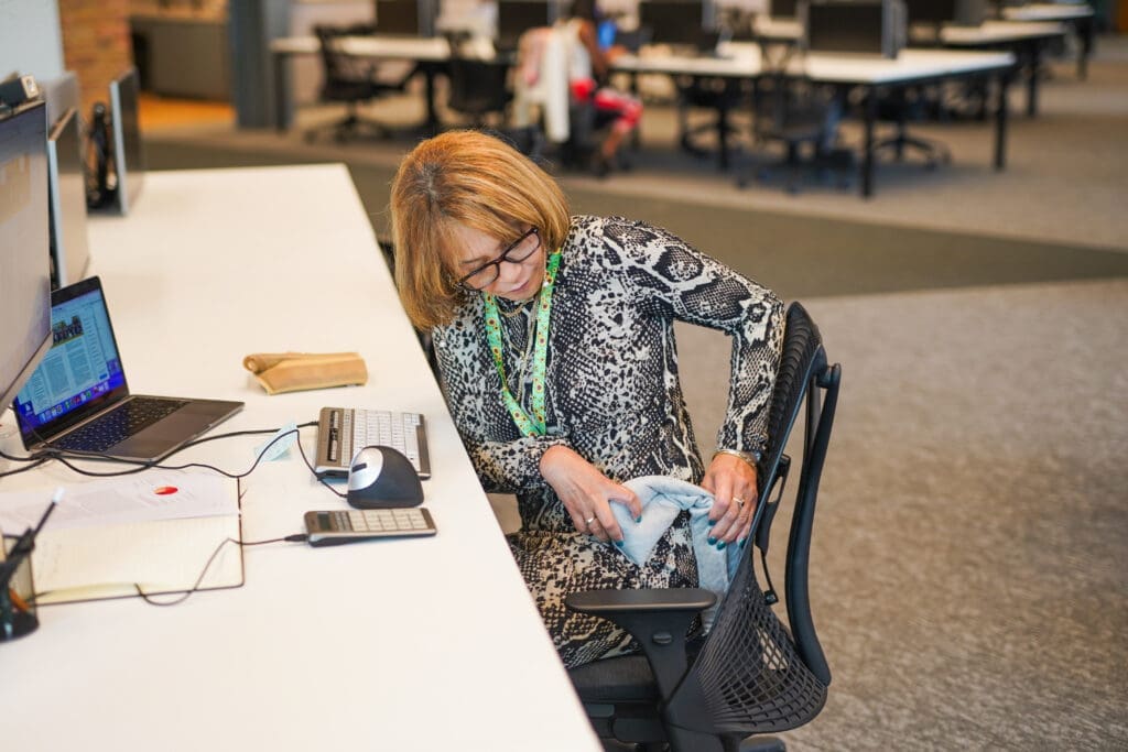 Person at desk adjusts heat pack for chronic pain