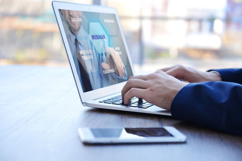Person's hands using laptop at the table in office against the window
