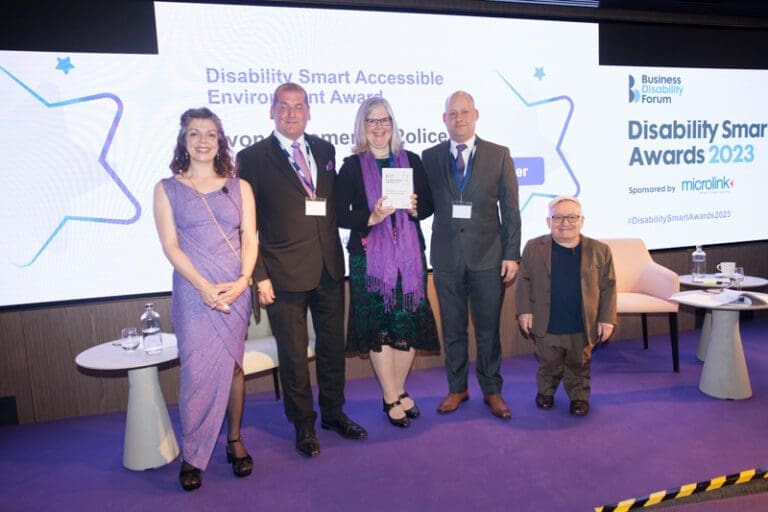 The Avon & Somerset Police team posing with their award on stage at the Disability Smart Awards 2023 ceremony.