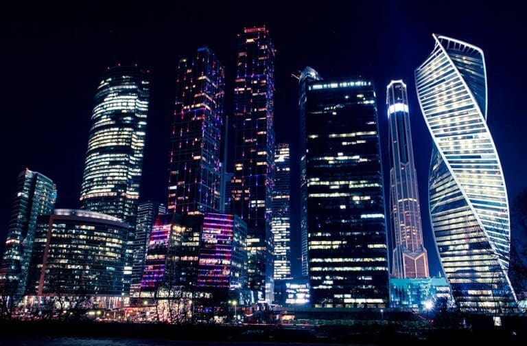 A city skyline of skyscrapers lit up at night.