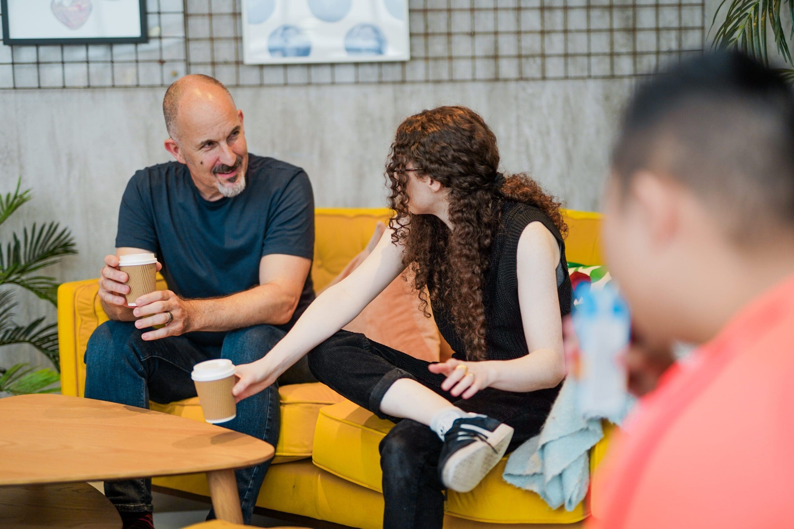 A Deaf person wearing hearing aids has a coffee with family A Deaf person wearing hearing aids has a coffee with family.