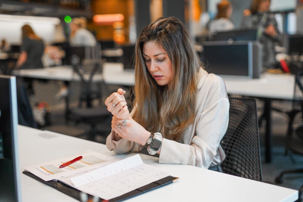 View all results Person experiences wrist pain at desk at work in office