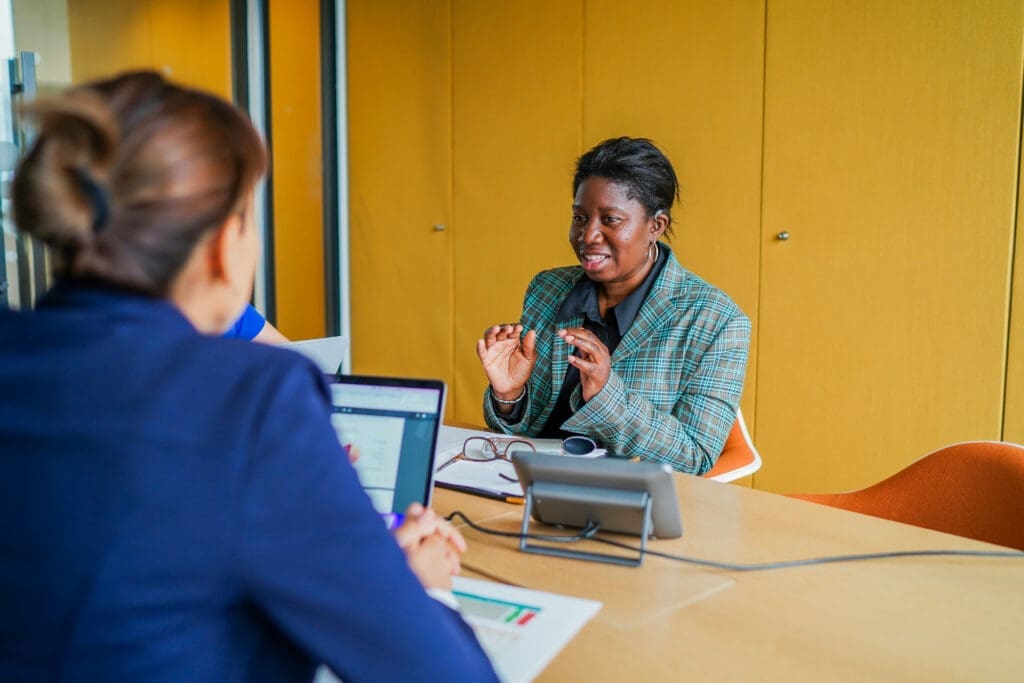A hearing aid user communicates with her colleague in a meeting