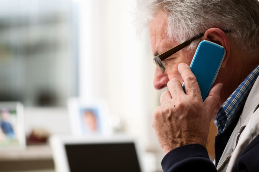 An older man uses a mobile phone