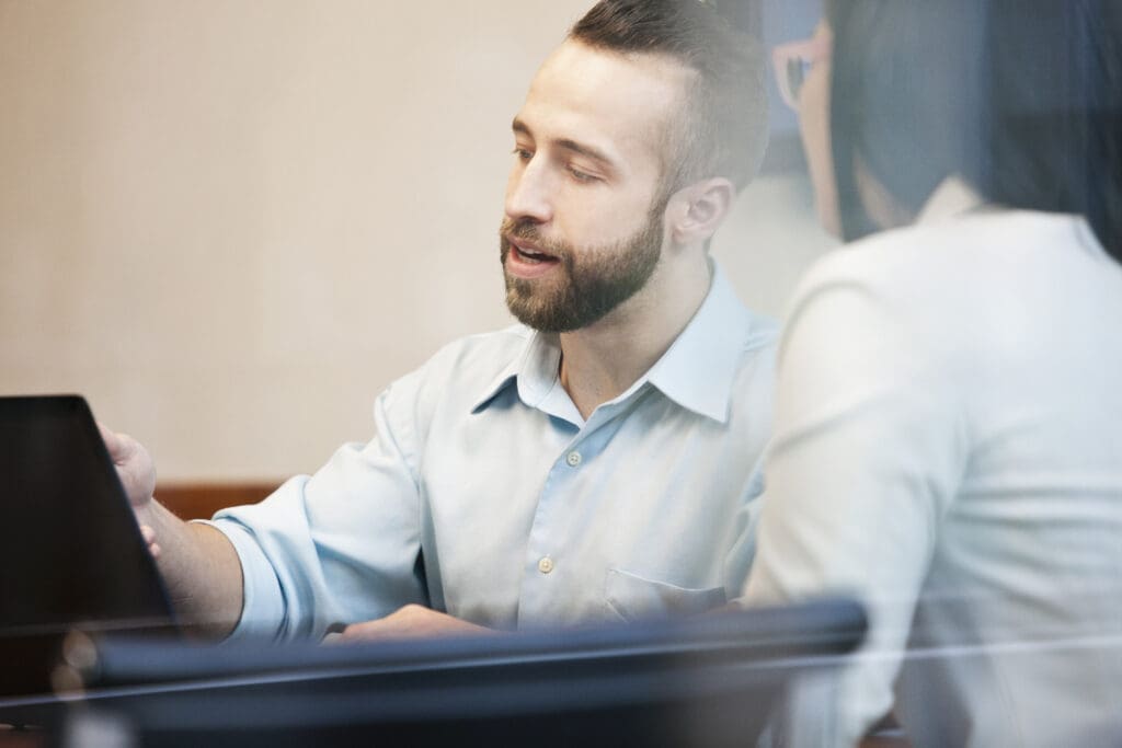 Man shows colleague info on a tablet