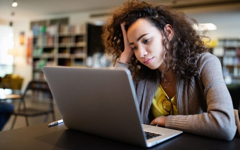 A woman using a laptop in a library