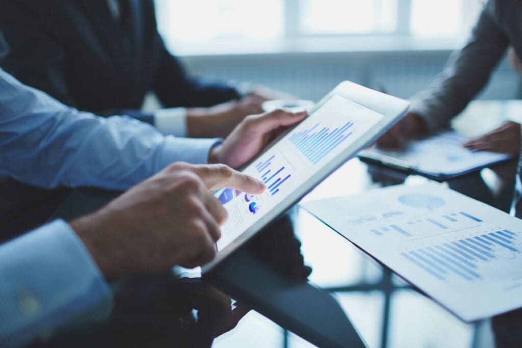 Person with a tablet displaying graphs and data