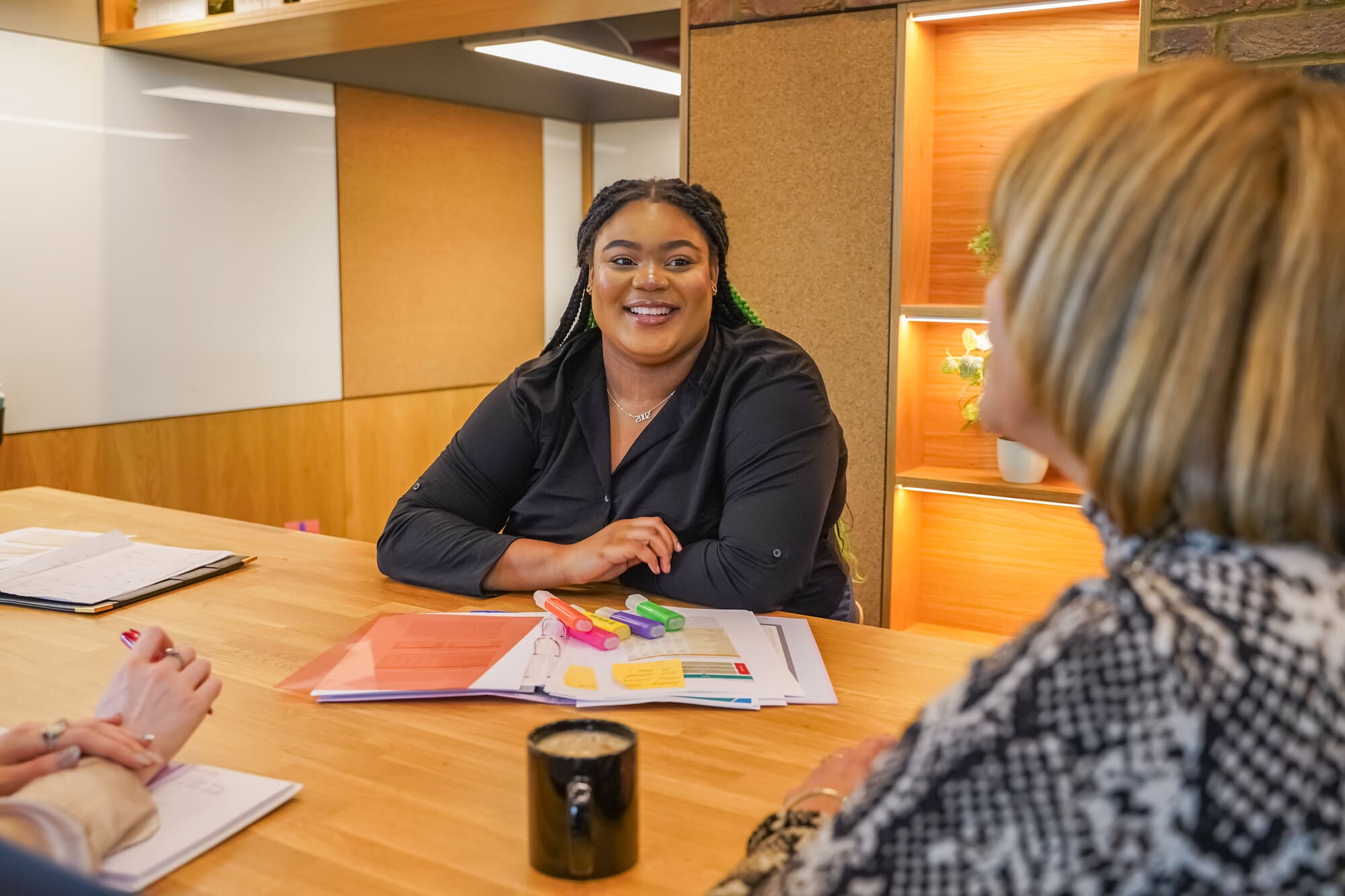 Person with less-visible disabilities meets with colleagues at a table Person with less-visible disabilities meets with colleagues at a table