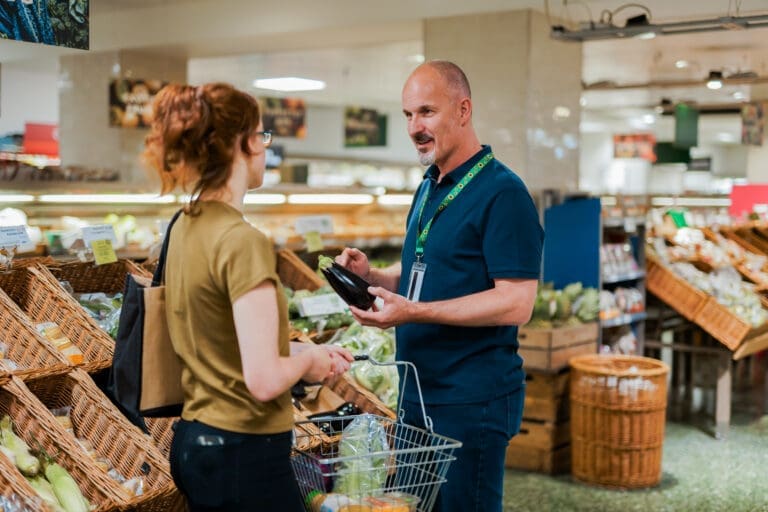 A ​Deaf ​sales ​assistant ​helps ​a ​customer ​who ​has ​a ​less-​visible ​disability ​(​PMDD)​ ​in ​a ​supermarket