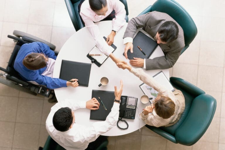 Aerial shot of people in a meeting including one wheelchair user.