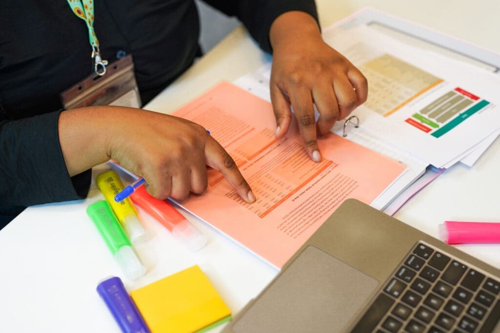 Person reads worksheets using tinted coloured overlay